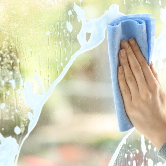 Woman cleaning window at home